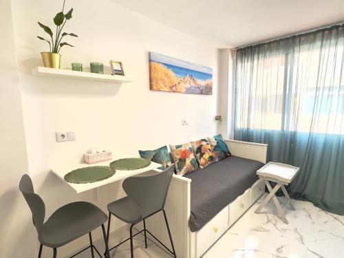 a room with a couch and a table and chairs at Apartamento estudio “The mirror” in Torrevieja