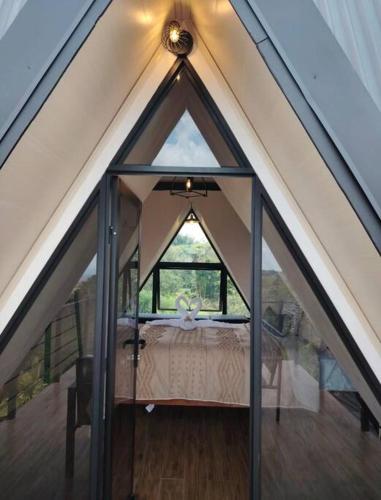an attic room with a bed in a tent at Alma Luna Villa Arenal in Monterrey