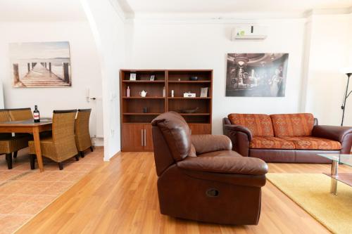 een woonkamer met een bank, een stoel en een tafel bij Danube Dwelling Asboth 19-1 in Boedapest