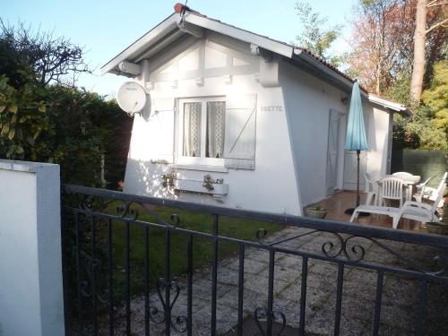 une petite maison blanche avec une terrasse couverte et des chaises dans l'établissement Petite villa calme à Arcachon, à Arcachon