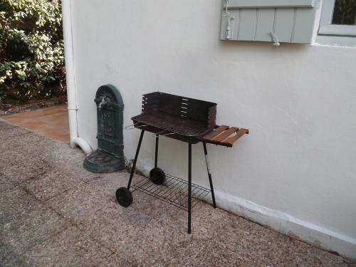 - un barbecue installé à côté d'un mur dans l'établissement Petite villa calme à Arcachon, à Arcachon