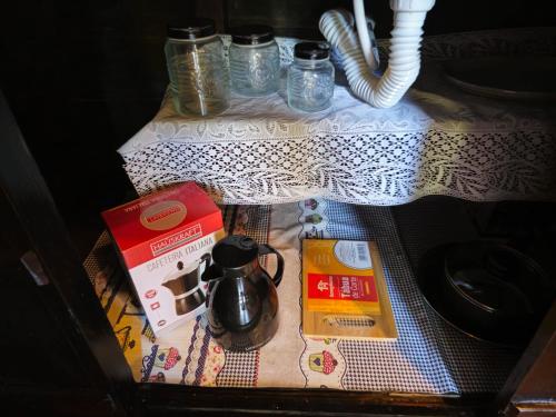 a table with a tea kettle and books on it at Recanto Curiaçu in Cunha