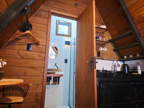 a kitchen with wooden walls and a door leading into a kitchen at Recanto Curiaçu in Cunha