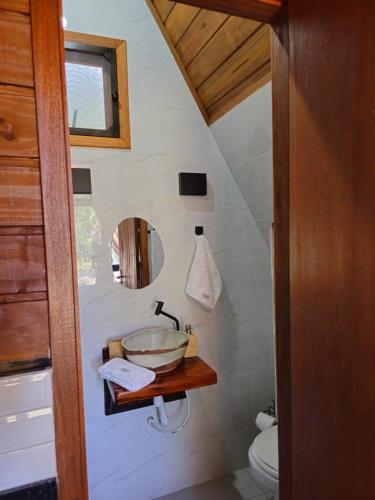 a bathroom with a sink and a bowl on a shelf at Recanto Curiaçu in Cunha