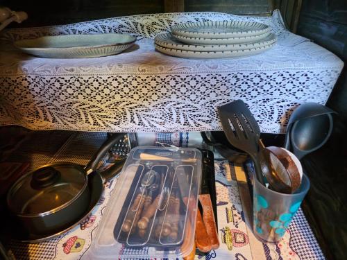 a table with plates and dishes and utensils on it at Recanto Curiaçu in Cunha