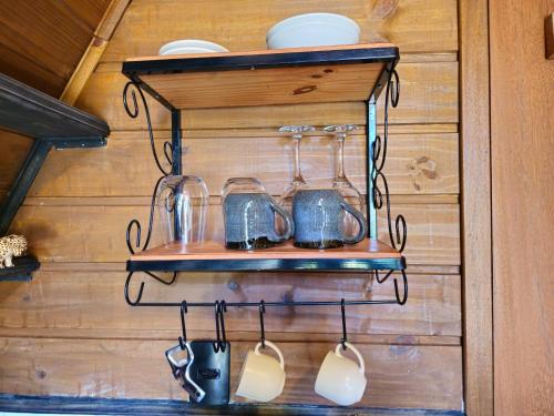a shelf with cups and utensils on a wall at Recanto Curiaçu in Cunha
