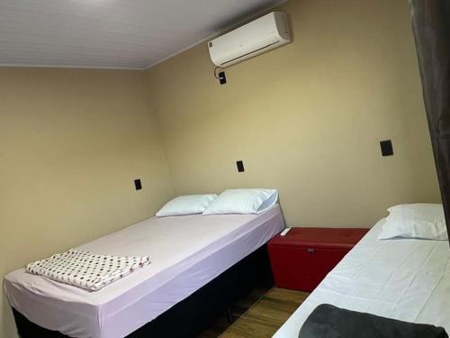 una camera con due letti e un condizionatore d'aria di Chalé sossego a Pirenópolis