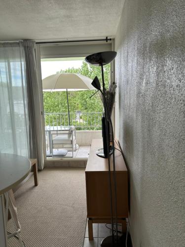 une lampe sur une table dans un salon avec un parapluie dans l'établissement Studio cosy centre ville et plage, à La Grande Motte