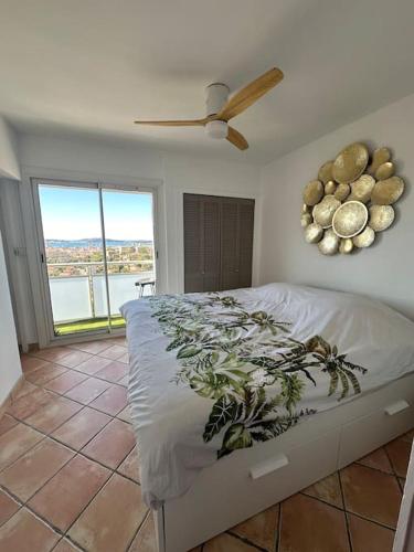 une chambre avec un lit avec un ventilateur et une fenêtre dans l'établissement Superbe appartement T3 lumineux, à Toulon