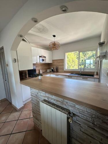 une cuisine avec un grand comptoir en bois dans l'établissement Superbe appartement T3 lumineux, à Toulon
