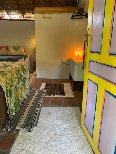 een slaapkamer met een bed en een deur open bij Casa Acquamarina in Atins