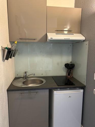une petite cuisine avec un évier et un micro-ondes dans l'établissement Studio cosy centre ville et plage, à La Grande Motte