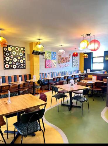 a dining room with wooden tables and chairs at Modern & Blissful Beach Park Holiday Home in Dovercourt, Essex, in Parkeston