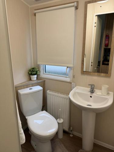 a bathroom with a toilet and a sink at Modern & Blissful Beach Park Holiday Home in Dovercourt, Essex, in Parkeston