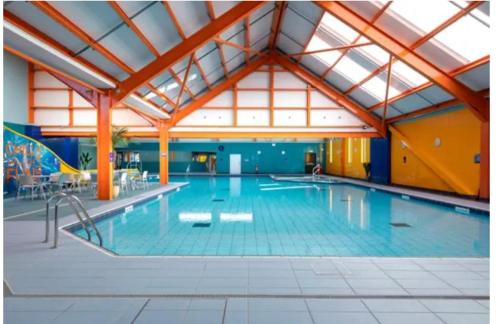 a large indoor swimming pool with a large ceiling at Modern & Blissful Beach Park Holiday Home in Dovercourt, Essex, in Parkeston