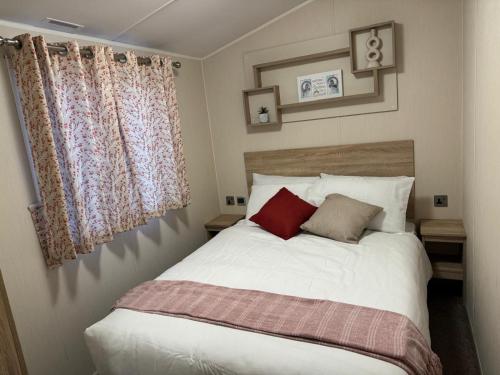 a bedroom with a white bed with two pillows at Modern & Blissful Beach Park Holiday Home in Dovercourt, Essex, in Parkeston