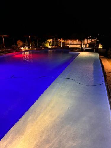 une grande piscine éclairée la nuit dans l'établissement La Siègià Resort spa, à Massa Marittima