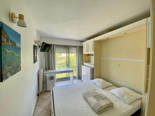 une chambre avec un lit et une télévision dans l'établissement L'oasis de Vallauris, piscine, parking privé, à Vallauris