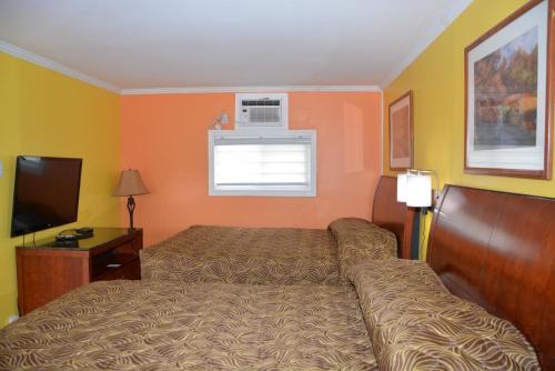 a hotel room with a bed and a television at Harmony Inn in Goderich