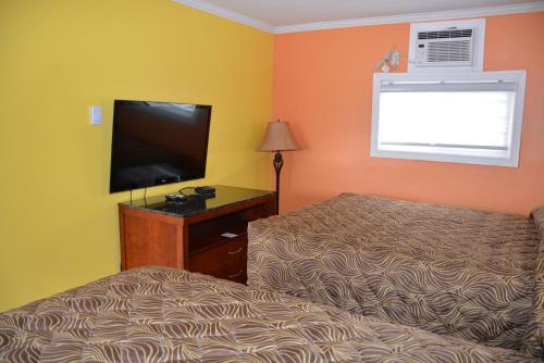 a bedroom with a bed and a flat screen tv at Harmony Inn in Goderich