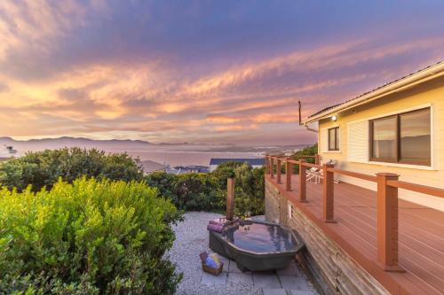 a boat sitting on a deck next to a house at Oceanfront bungalow 3 br/2 ba, Wifi Fireplace: Guppy Huys in De Kelders