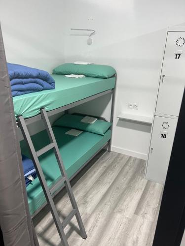 a bunk bed in a dorm room with a ladder at O Albergue de Fene in Fene
