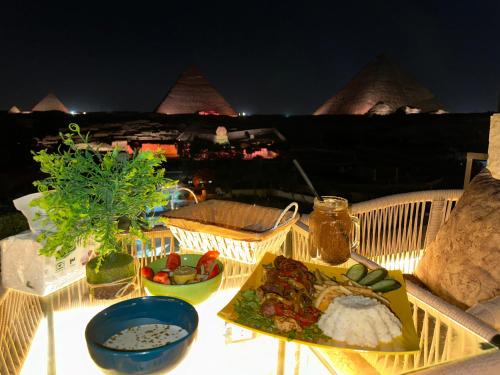 - une table avec une assiette de nourriture sur le balcon dans l'établissement Sahara Pyramids Inn, au Caire