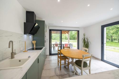a kitchen with a wooden table and a dining room at Gîte de Lamourelle in Lacquy