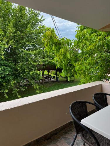 uma varanda com mesa, cadeiras e árvores em Apartments Rudaj em Ulcinj
