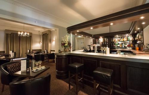 a bar in a restaurant with tables and chairs at Forest Lodge Hotel in Lyndhurst