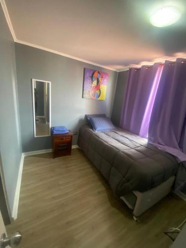 1 dormitorio con 1 cama con cortinas moradas en casa, en La Chimba