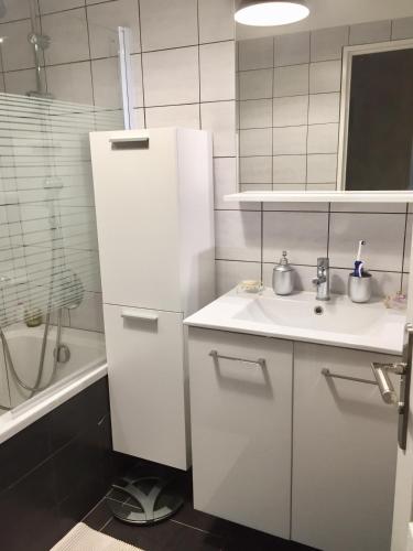 La salle de bains est pourvue d'un évier et d'un réfrigérateur blanc. dans l'établissement Beau 4P dans résidence de standing avec piscine, à Nice