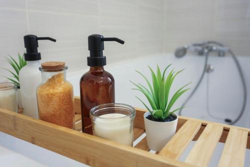 un plateau en bois avec des bouteilles de savon et une plante dans l'établissement Superbe Maison familiale récente et cosy, à Amiens