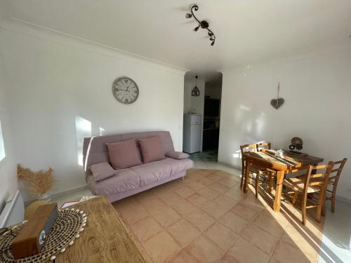 sala de estar con sofá púrpura y mesa en Ô Coeur Des Ocres, en Roussillon
