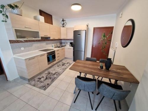 a kitchen with a wooden table and blue chairs at Zen zone apartment-free parking-290m to the beach in Kastellákia