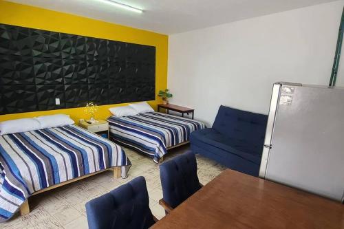 a room with two beds and a table and a chair at Casa Habitación Frida Valentina in Tequila
