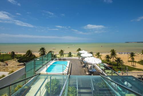 a view of the beach from a building with a swimming pool at Hotel Corais de Tambau in João Pessoa