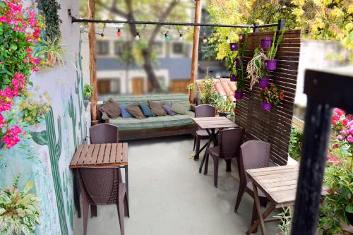 d'une terrasse avec des tables, des chaises et un canapé. dans l'établissement Pequeña Estación B&B, à Mendoza