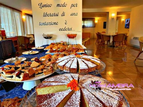 a table filled with different types of cakes and pies at HOTEL AMBRA - Fronte Mare - Vicinissimi al Centro in Milano Marittima
