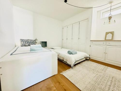 una camera bianca con un letto e un tappeto di Villa Nola Cascais a Cascais