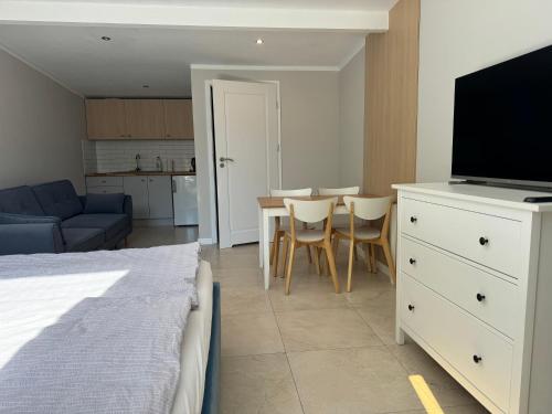 a living room with a bed and a dining room table at Apartamenty i Domki WyDmy Międzywodzie in Międzywodzie