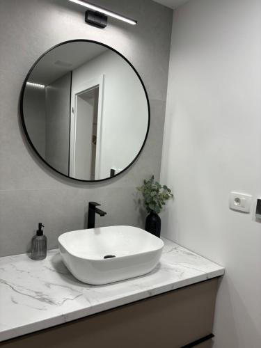 a bathroom with a white sink and a mirror at LARUS apartment in Kastel Luksic