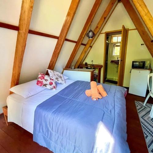 a bedroom with a blue bed with two pillows on it at Recanto agape chalés e cabana in Rosas