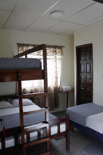 a bedroom with two bunk beds and a window at Hotel Estación del Sol in Las Núñez
