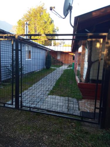 a gate to a backyard with a yard at Cabaña "El Gringo" in Coñaripe