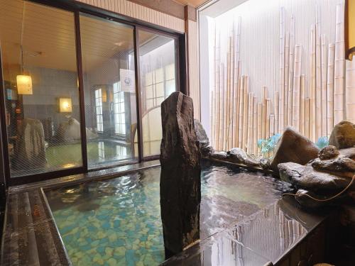 um quarto com piscina de água num edifício em Dormy Inn Express Mikawaanjo em Anjomachi