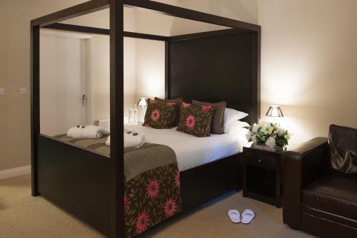 a bedroom with a bed and a dresser at Forest Lodge Hotel in Lyndhurst