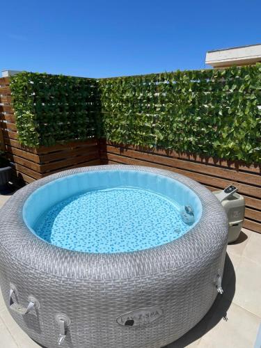 a hot tub in a yard with a hedge at Luxury Rooftop Vlora in Vlorë