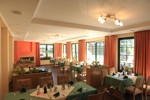 a restaurant with green tables and chairs and windows at Gasthof & Pension Zum Himmel in Rubenow