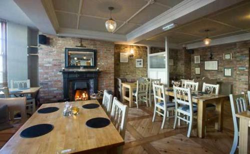 a restaurant with a table and chairs and a fireplace at The Tailor's House Guest Rooms in Dunmoyle